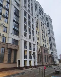 un gran edificio blanco en una calle de la ciudad en Prestige Apartments en Rivne