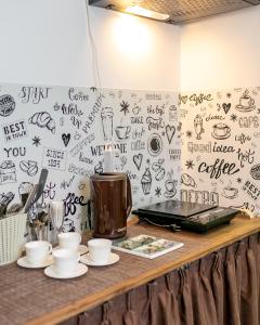 ボロヴィチにあるГостиница Винтажのカップ付きカウンター、コーヒーメーカー(壁に設置)