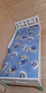 a bed with a blue comforter with animals on it at Cabana Larisei in Cluj-Napoca