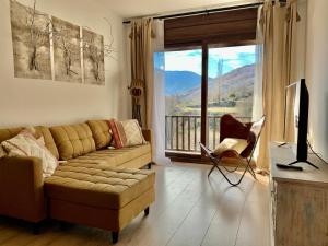 a living room with a couch and a large window at Apartament La Ruella in Sort