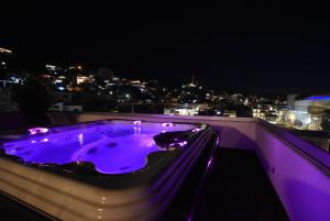 Condominio Panamá في بويرتو فايارتا: حوض استحمام ساخن على سطح مبنى في الليل