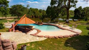 een zwembad met een vuurplaats in een tuin bij Pousada Araras Pantanal Eco Lodge in Carvoalzinho