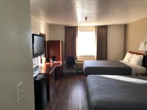 Postel nebo postele na pokoji v ubytování Ameri-Stay Inn & Suites