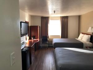 a hotel room with two beds and a flat screen tv at Ameri-Stay Inn & Suites in Clearfield
