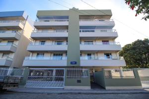 un edificio alto con una valla delante en Aluguel Apartamento 2 quartos s/ 1 suíte Bombas/SC, en Bombinhas