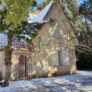a house in the snow with a tree in front at Chalet ifrane in Ifrane