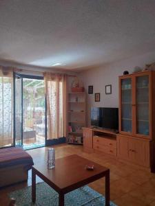 salon z telewizorem i stolikiem kawowym w obiekcie Apartamento Neptuno playa 06 w mieście Puerto de Santiago