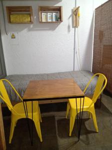 stół i dwa żółte krzesła obok łóżka w obiekcie 573 APART w mieście Mendoza