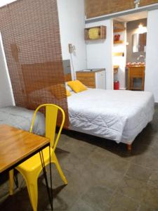 sypialnia z łóżkiem, stołem i żółtymi krzesłami w obiekcie 573 APART w mieście Mendoza