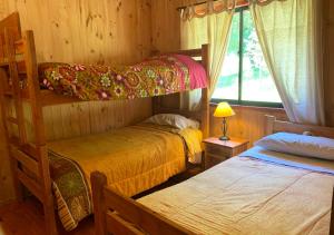 1 dormitorio con 2 literas y ventana en Mirador Los Volcanes Lodge & Boutique, en Pucón
