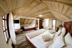 a bedroom with two beds and a large wooden ceiling at Etno hotel Balasevic Rtanj in Boljevac