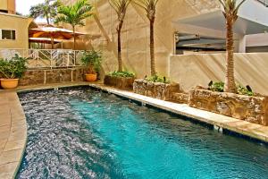 a pool in a house with palm trees in it at The Equus in Honolulu