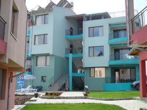 a blue apartment building with stairs and a yard at Dream Bay Family Hotel in Tsarevo