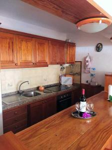 uma cozinha com uma mesa com dois copos de vinho em Apartamento Neptuno playa 06 em Puerto de Santiago