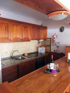 kuchnia ze stołem z 2 kieliszkami wina w obiekcie Apartamento Neptuno playa 06 w mieście Puerto de Santiago