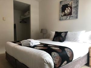 a bed with a white comforter and pillows at Accent Accommodation@Docklands in Melbourne