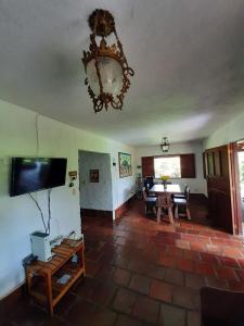 sala de estar con TV y lámpara de araña en Finca La Esperanza, en Calima