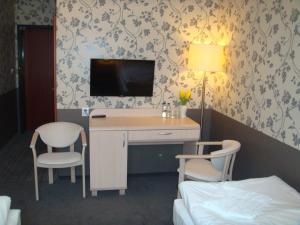 Cette chambre comprend un bureau, une télévision et un lit. dans l'établissement Zajazd Mat, à Bełk