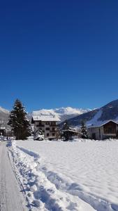 a snow covered road in front of a building at Baita nei pra in Bormio