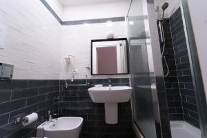 uma casa de banho com um lavatório, um WC e um espelho. em PC Boutique H Loggia, by ClaPa Group em Nápoles