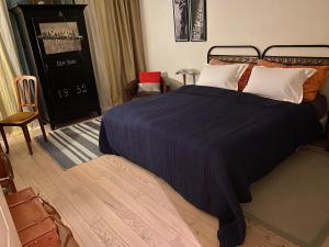 - une chambre avec un lit doté d'une couverture bleue et d'une chaise dans l'établissement Les 3 Coeurs - Chambres chez charmants habitants, à Font