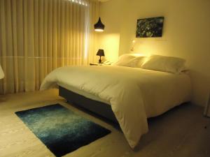 a bedroom with a large white bed and a window at The Grace Hotel in Bogotá
