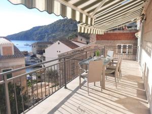 un patio con tavolo e sedie sul balcone. di Apartments Villa Beba a Komiža