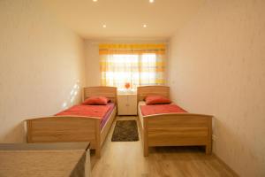 two beds in a small room with a window at Mainzimmer - Business Apartments in Hasloch