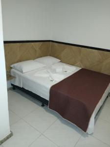 uma pequena cama num quarto com em Pousada Solar da Praia em Guarapari