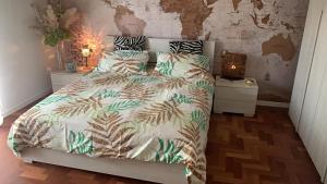 - une chambre avec un lit et une couette verte et blanche dans l'établissement A casa da Manuela, à Parme
