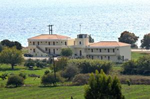 a large white building in front of the water at Finiki Plaza in Methoni