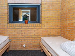 2 Betten in einer Ziegelwand mit einem Fenster in der Unterkunft Holiday home Ørsted XVII in Ørsted