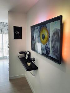 einen Flachbild-TV, der an einer Wand hängt in der Unterkunft Appartement les Falaises in Cap d'Agde