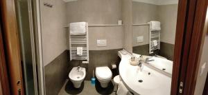 a bathroom with a toilet a sink and a mirror at Hotel Alpi Resort in Turin