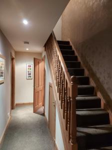 uma escada numa casa com uma escada de madeira em Holiday House Kinveachy em Aviemore