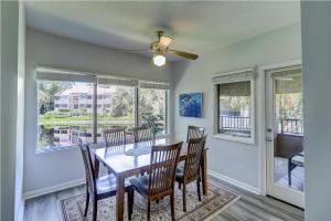 a dining room with a table and chairs and windows at Granite New Furniture King Queen Sleeps 6 Bikes & Beach Gear included in Hilton Head Island