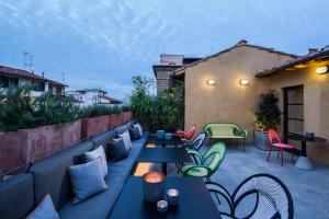 a patio with tables and chairs on a rooftop at Hotel Milù in Florence