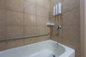 a bathroom with a white tub and a shower at Bayview Hotel in Courtenay