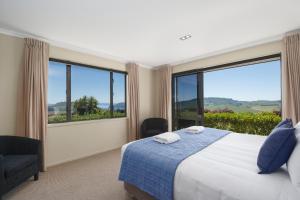 una camera con letto e ampie finestre di Scenic Solitude - Wake up to Lake and Mountain Views! a Taupo