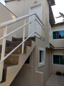un escalier d'un bâtiment avec rampe d'escalier dans l'établissement Aluguel temporada no Centro de Búzios, à Búzios