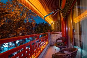 balcón con 2 sillas y ventana en Xi'an See Tang Guesthouse en Xi'an