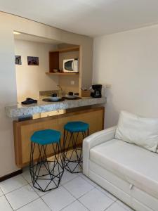 a living room with a couch and two blue stools at Casa na Beira da Praia da Pipa Beach House Luxury in Pipa