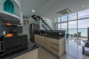 a kitchen with a sink and a refrigerator and a staircase at MURANO ELITE NEW OCEAN FRONT DUPLEx in Cartagena de Indias