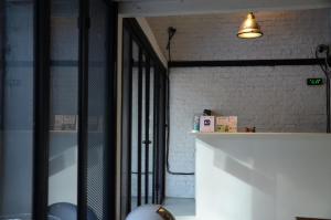 a room with a white brick wall and a light at 3Howw Hostel Khaosan in Bangkok