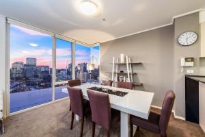 a dining room with a white table and chairs and a clock at Exclusive Stays - The Centurion in Melbourne