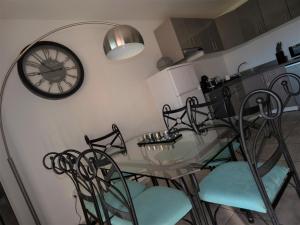 a dining room with a glass table and a clock on the wall at Palm Beach in Le Gosier