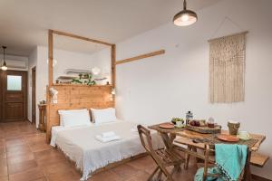 een slaapkamer met een bed en een eettafel bij Althea Beachside Apartments in Potokáki