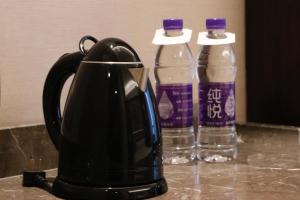 - une cafetière et 2 bouteilles d'eau sur un comptoir dans l'établissement Shangri-La Qufu, à Qufu