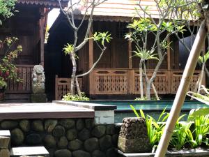 a house with a pool and trees in front of it at Melati Bali Homestay in Canggu