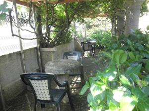 ビーゴにあるHotel Playa Samil Vigoの庭園内の椅子・テーブル